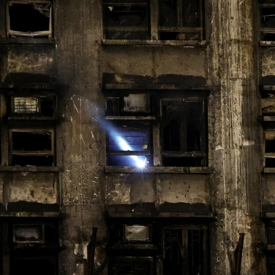 FILE PHOTO: A rescuer works inside a damaged building at the scene after a deadly fire at the Wang Fuk Court housing complex in Hong Kong, China November 27, 2025. REUTERS/Amr Alfiky/File Photo
