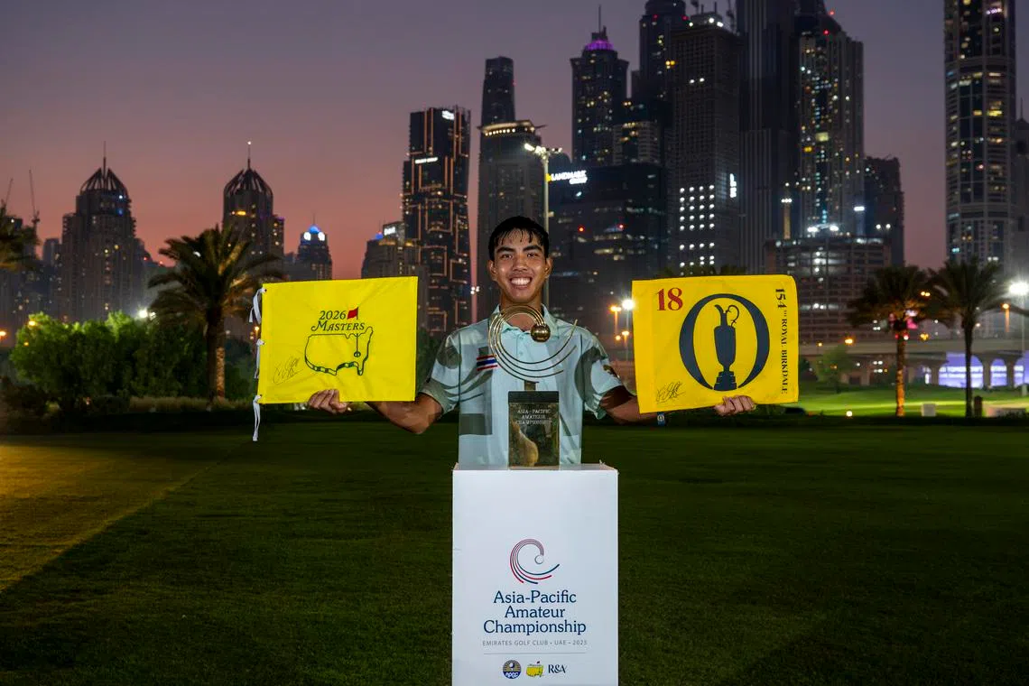 Fifa Laopakdee lifts the 154th Open Championship flag and the Masters flag alongside the Asia-Pacific Amateur Championship trophy after winning the 2025 Asia-Pacific Amateur Championship in Dubai on Oct 26, 2025.
