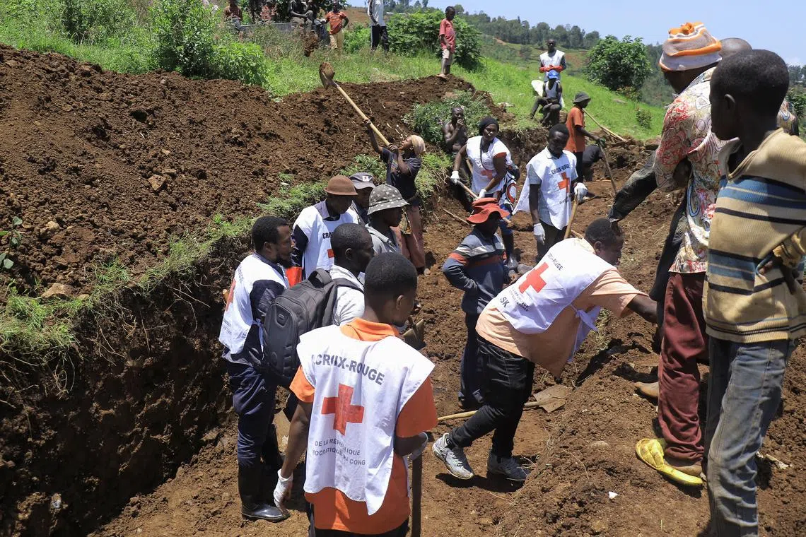 FILE PHOTO: Members of the International Committee of the Red Cross (ICRC) dig a common grave at the Musigoko cemetery for the burial of bodies, following clashes between M23 rebels and the Armed Forces of the Democratic Republic of the Congo (FARDC),in Bukavu, eastern Democratic Republic of Congo February 19, 2025. REUTERS/Victoire Mukenge/File Photo
