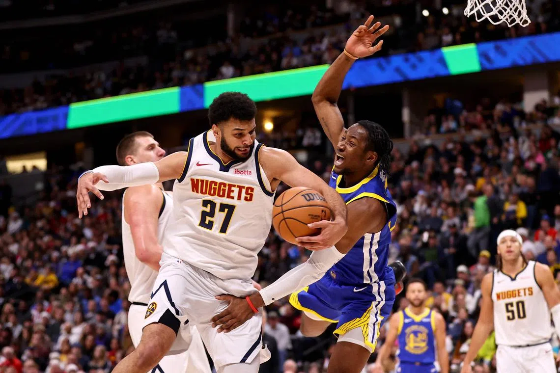 Denver Nuggets' Jamal Murray (No. 27) driving to the basket as the Golden State Warriors' Jonathan Kuminga tries to stop him during their Christmas Day clash.