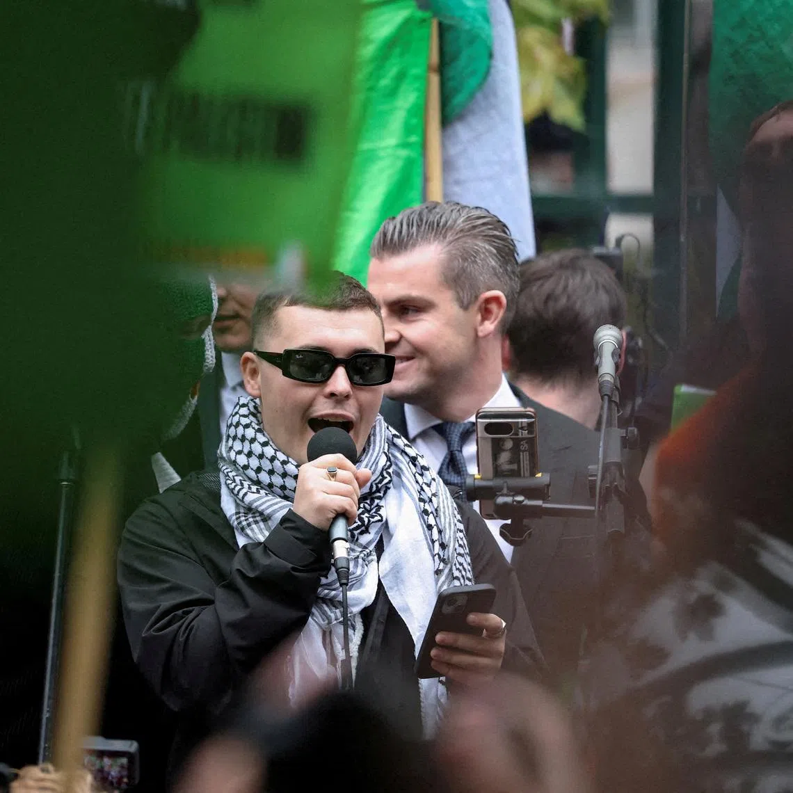 FILE PHOTO: Member of Kneecap Liam O'Hanna, also known as Liam Og O hAnnaidh and performing under the name of Mo Chara, speaks to supporters outside Woolwich Crown Court, after a UK court threw out his prosecution for a terrorism offence, in London, Britain, Friday September 26, 2025. REUTERS/Hannah McKay/File Photo