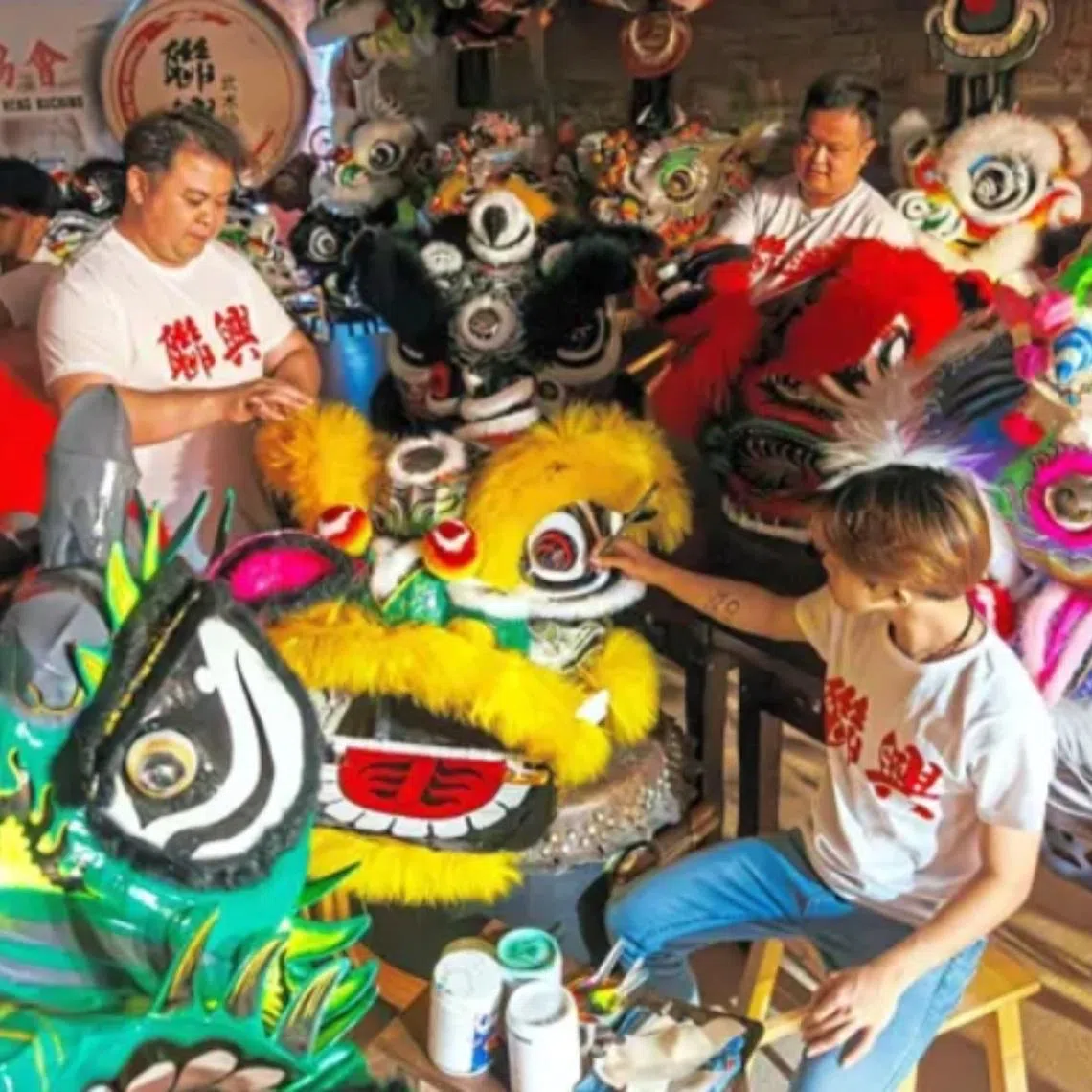 Mr Ronny Chin (second from left) and his staff members decorating their range of lion heads for the upcoming Chinese New Year celebrations. 