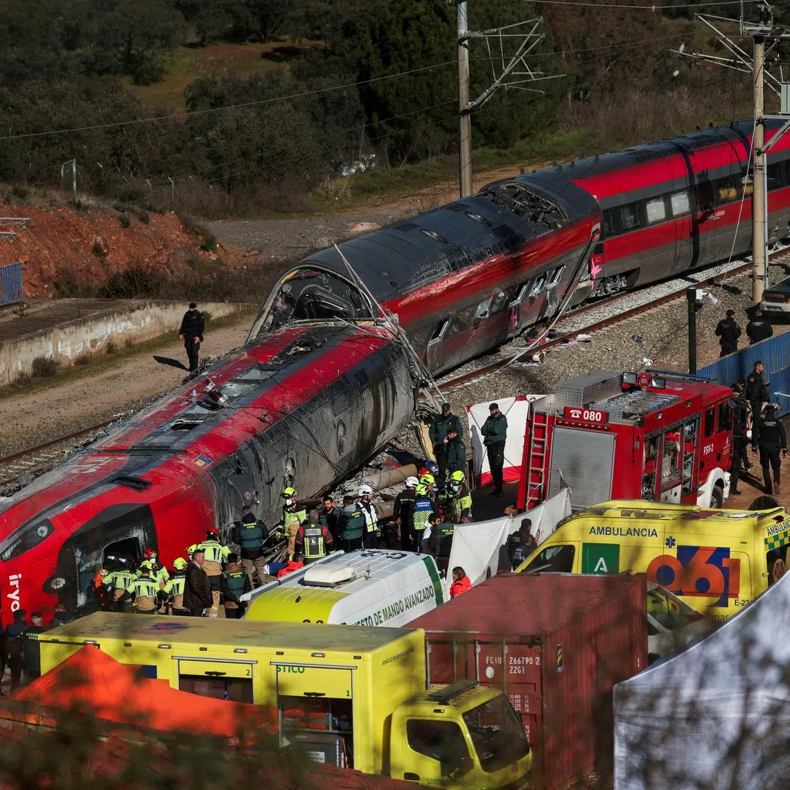 FILE PHOTO: Members of the Spanish Civil Guard, along with other emergency personnel, work next to one of the trains involved in the accident, at the site of a deadly derailment of two high-speed trains near Adamuz, in Cordoba, Spain, January 19, 2026. REUTERS/Susana Vera/File Photo