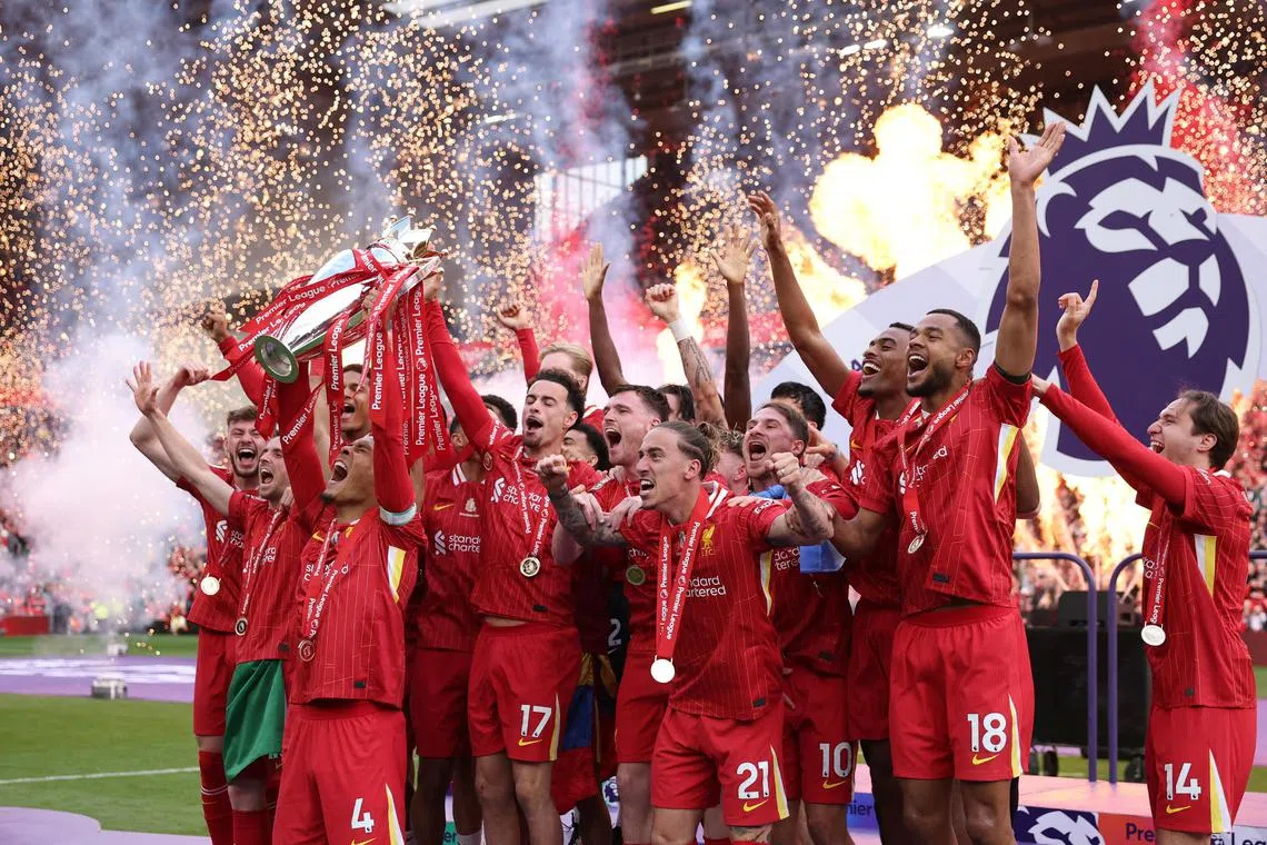 Liverpool's Virgil van Dijk lifts the trophy as he celebrates with teammates after winning the Premier League.