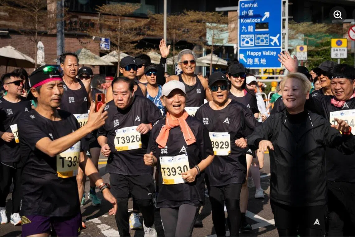 Chow Yun Fat (back row, middle, waving hand) with Kent Cheng (T3926), Nina Paw (T3930) and Lau Kong (T3929) at the Standard Chartered Hong Kong Marathon on Jan 18.
