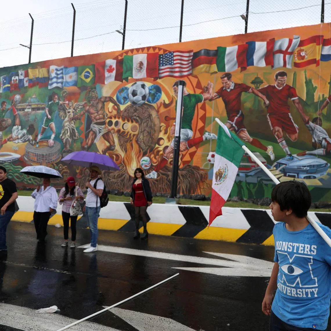 People walk in front of a football-themed mural spanning more than 200 square meters, which aims to break a Guinness World Record before the 2026 World Cup, in Mexico City, Mexico, May 24, 2026. REUTERS/Luis Cortes
