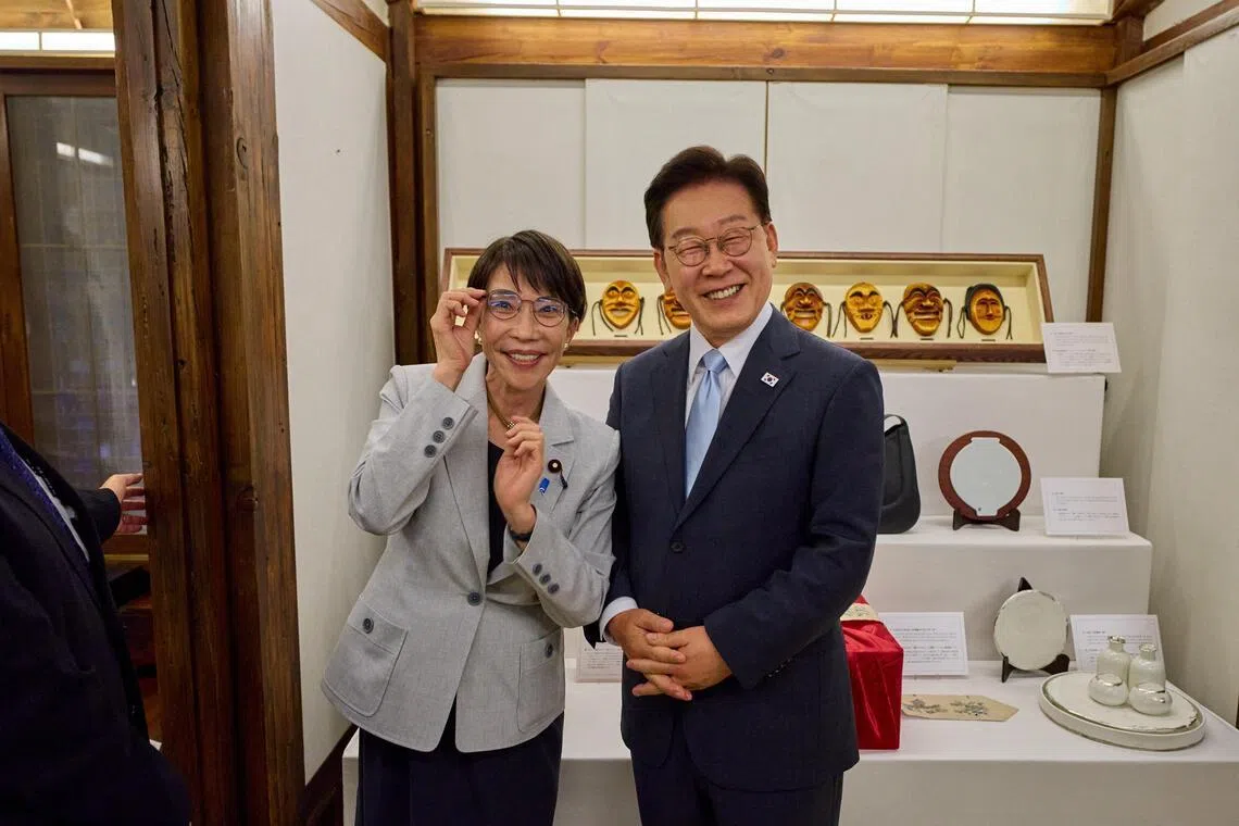 Japanese Prime Minister Sanae Takaichi poses for photographs with glasses received from South Korean President Lee Jae Myung, in Andong, South Korea, on May 19, 2026.