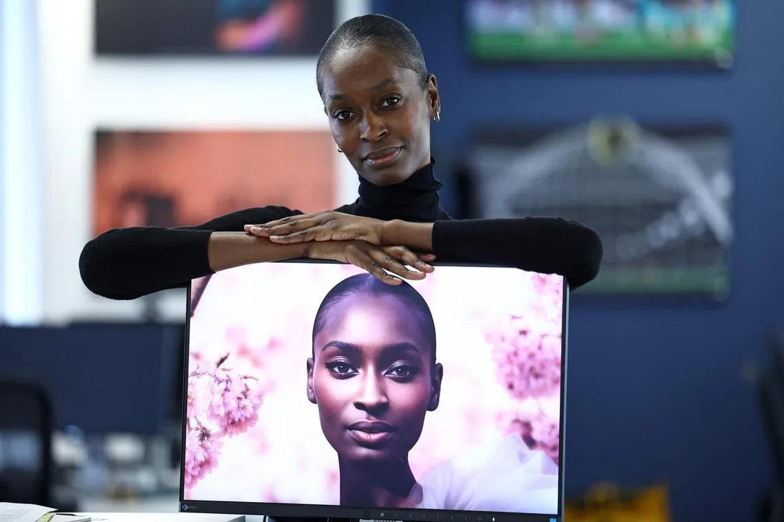 London-based model Alexsandrah Gondora poses for a photograph with her on-screen AI twin Alex, created by digital modelling agency, The Diigitals, in the AFP offices in London on Feb 21. 