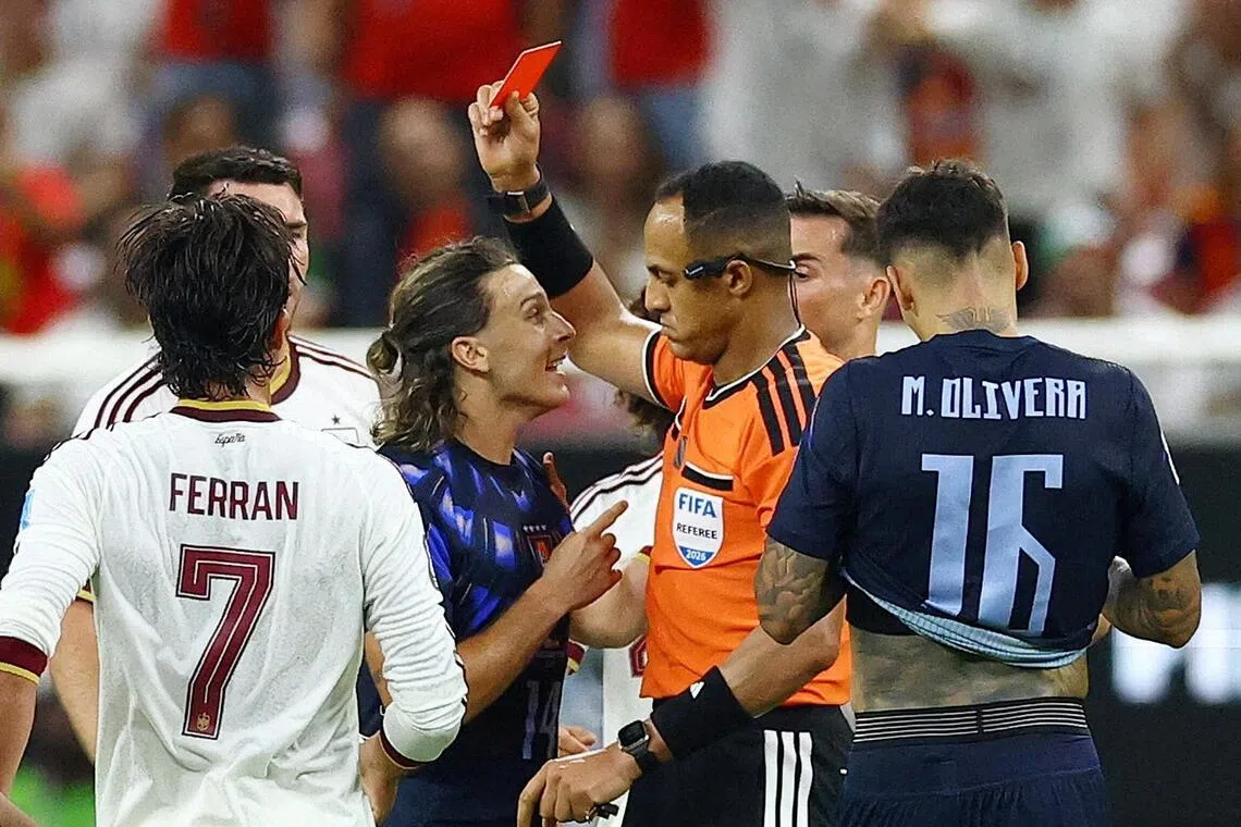 Referee Ismail Elfath showing a red card to Uruguay’s Agustin Canobbio during their 1-0 loss to Spain in a World Cup Group H match on June 26.