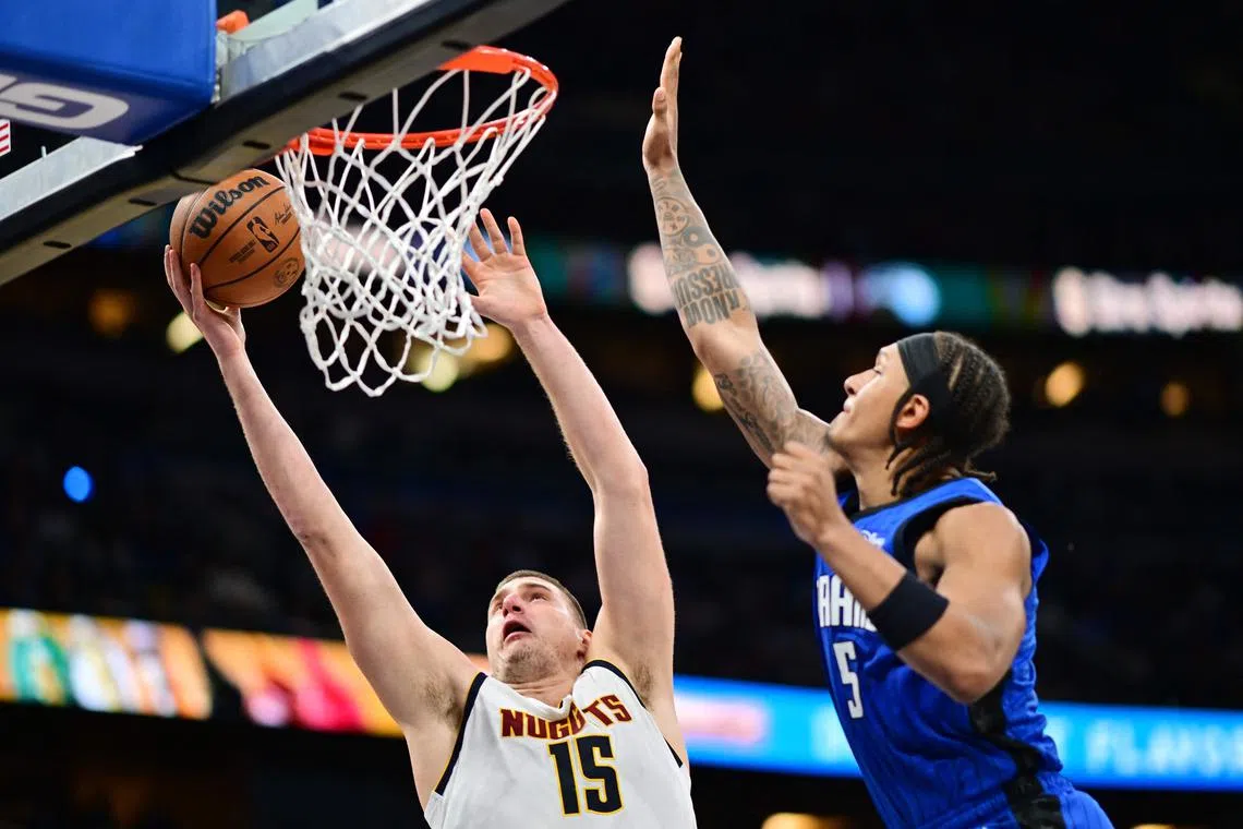 Nikola Jokic of the Denver Nuggets shoots the ball against Paolo Banchero of the Orlando Magic in the first half at Amway Centre.