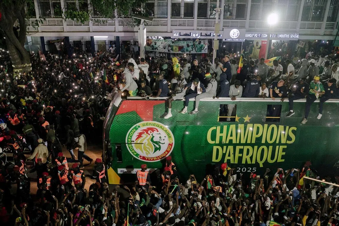 Senegal's players celebrate winning the Africa Cup of Nations atop an open bus during a trophy parade in the streets of Dakar.