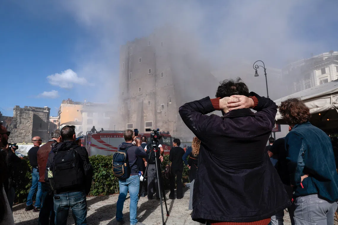 Onlookers watch as dust rises following collapses of parts of the Torre dei Conti, near Via dei Fori Imperiali, near the Colosseum, in Rome, Italy, November 3, 2025. REUTERS/Remo Casilli