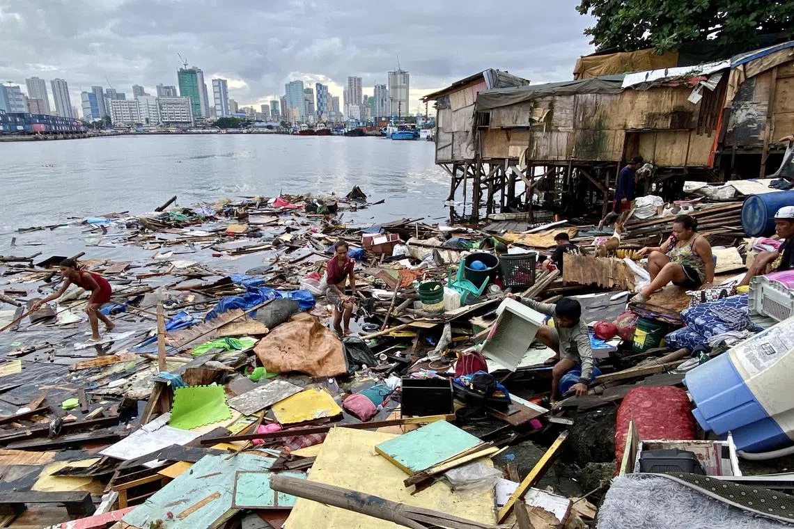 epa10894924 Villagers collect belongings following a storm surge brought by an approaching typhoon that destroyed their homes, at a coastal village in Manila, Philippines, 02 October 2023. The Philippine government weather bureau warned residents in northern Luzon island of possible flash floods and landslides that may be triggered by heavy rains brought by tropical cyclone Koinu, which recently reached typhoon category. Koinu is located 675 kilometers east of Aparri, Cagayan province packing maximum sustained winds of 120 kilometers per hour (kph) near the center and gustiness of up to 150 kph.  EPA-EFE/FRANCIS R. MALASIG