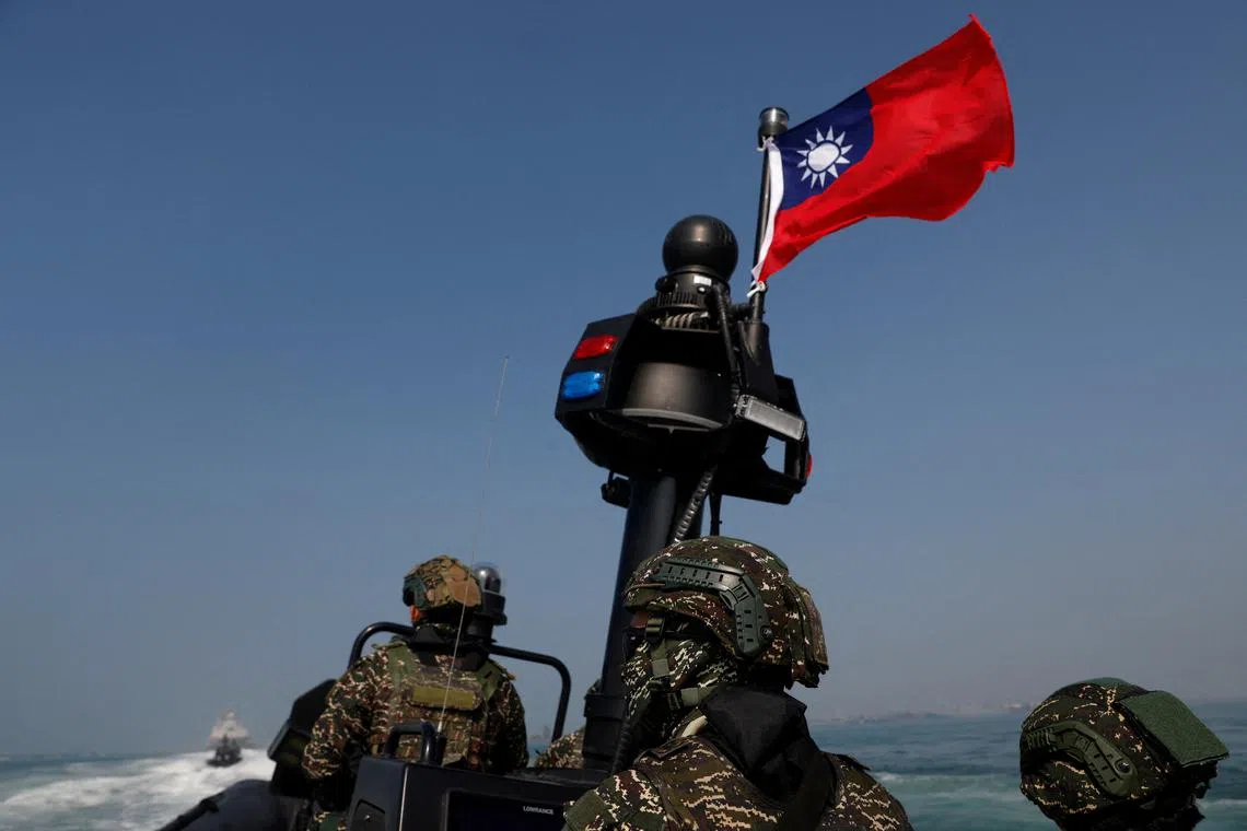 FILE PHOTO: Members of Taiwan's Navy and media onboard a special operation boat with a Taiwanese flag fluttering over it during a drill part of a demonstration for the media, to show combat readiness ahead of the Lunar New Year holidays, on the waters near a military base in Kaohsiung, Taiwan January 31, 2024. REUTERS/Carlos Garcia Rawlins/File Photo