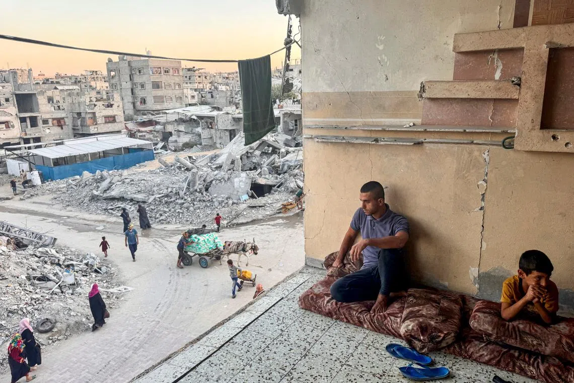 Palestinians rest near rubble of houses destroyed in Israeli strikes, amid the Israel-Hamas conflict, in Khan Younis in the southern Gaza Strip, September 30, 2024. REUTERS/Mohammed Salem/File Photo