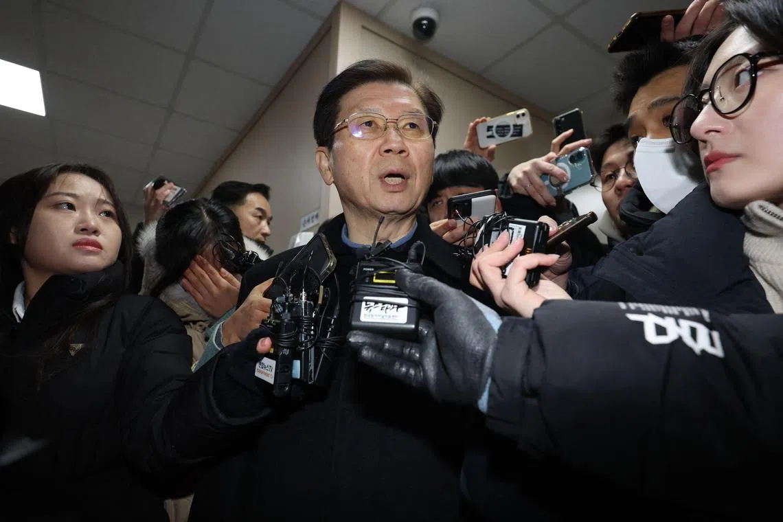 Head of Presidential Security Service (PSS) Park Chong-jun (C) is surrounded by media in the National Office of Investigation in Seoul on January 10, 2025. South Korea's presidential security chief resigned on January 10 as he faced questioning over why his guards prevented the detention of impeached President Yoon Suk Yeol and investigators prepared to make a fresh arrest attempt. (Photo by YONHAP / AFP) / South Korea OUT / NO ARCHIVES -  RESTRICTED TO SUBSCRIPTION USE