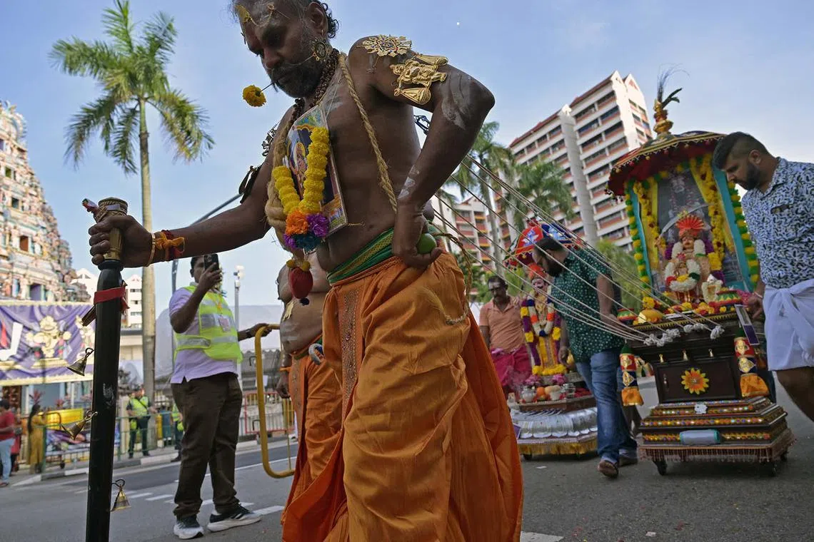 A devotee pulling a chariot from his back pierced with hooks, walking from Sri Srinivasa Perumal Temple to Sri Thendayuthapani Temple during the Hindu festival of Thaipusam in Singapore, Feb 11, 2025.