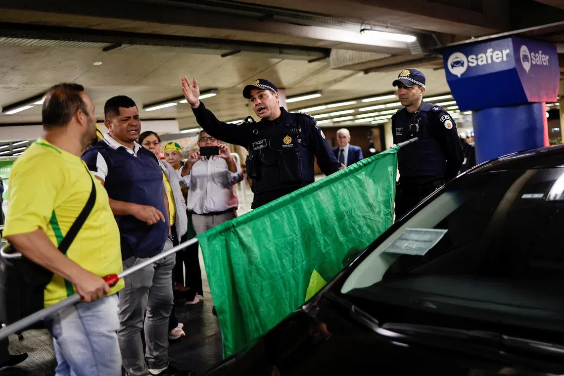 Members of the police forces talk with Bolsonaro supporters while reinforcing security at the airport.