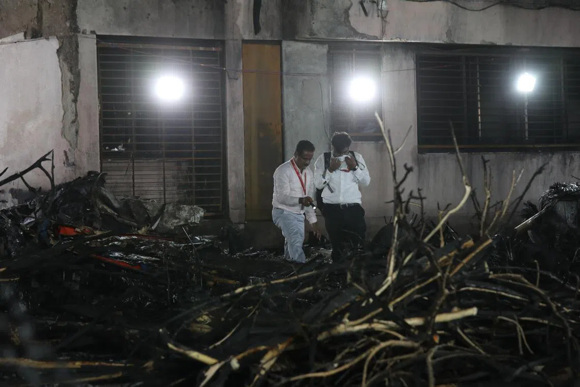 Officials inspecting the site of a plane crash near Sardar Vallabhbhai Patel International Airport in Ahmedabad, Gujarat, western India, June 12, 2025. 
