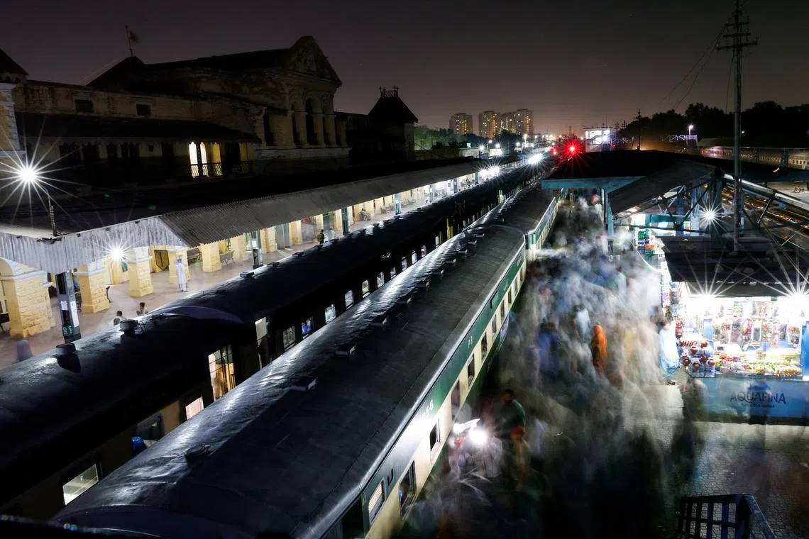 FILE PHOTO: Passengers get on board a train at the Cantonment railway station in Karachi, Pakistan, April 8, 2024. REUTERS/Akhtar Soomro/File Photo