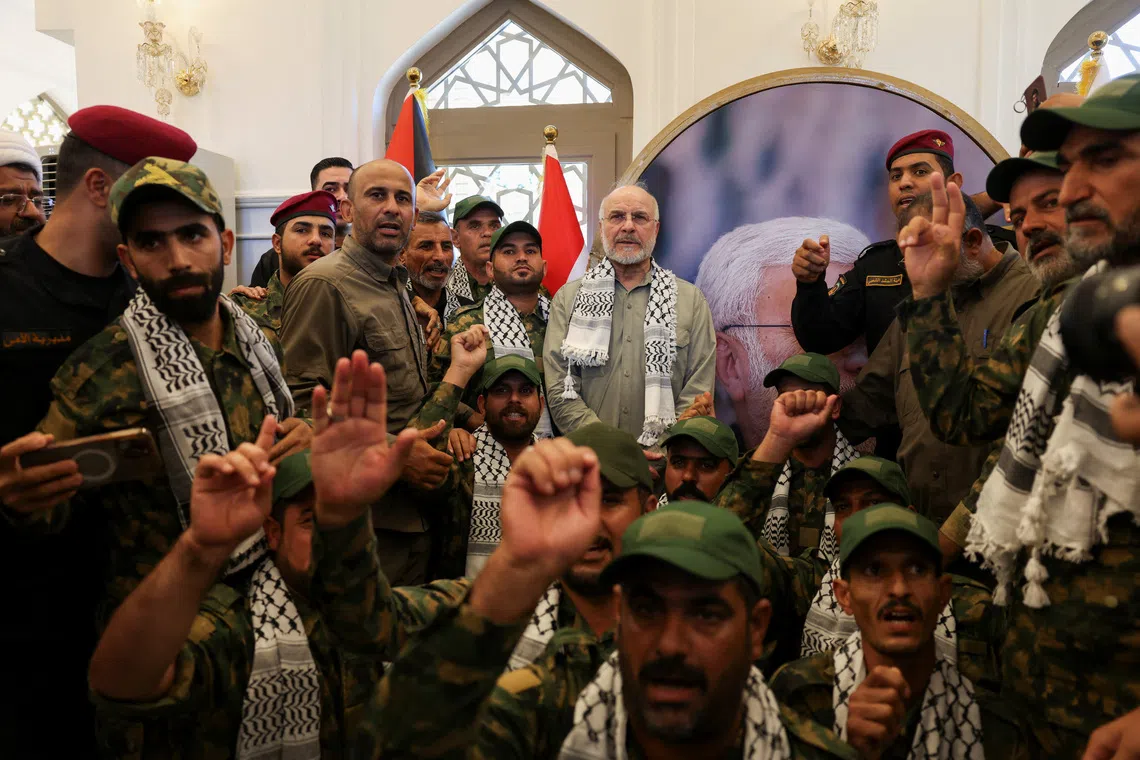Iranian Parliament Speaker Mohammad Baqer Qalibaf stands with members of Iraq's Popular Mobilization Forces at the grave of Iraqi paramilitary commander Abu Mahdi al-Muhandis, who was killed alongside Iranian military commander Qassem Soleimani in a U.S. drone strike near Baghdad International Airport in January 2020, in Najaf, Iraq, August 21, 2026. REUTERS/Ahmed Saad