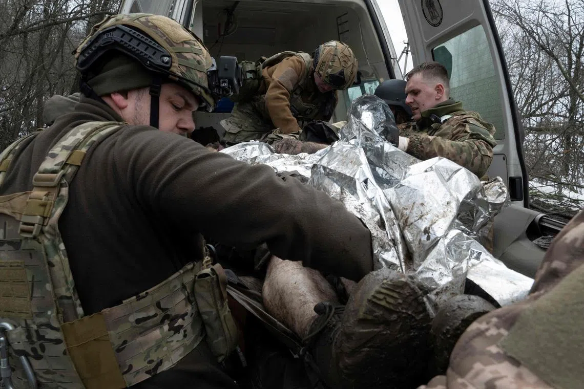 Medics from the Da Vinci Wolves Battalion evacuate a wounded Ukrainian serviceman near the front line in Bakhmut, in Ukraine's Donetsk region.