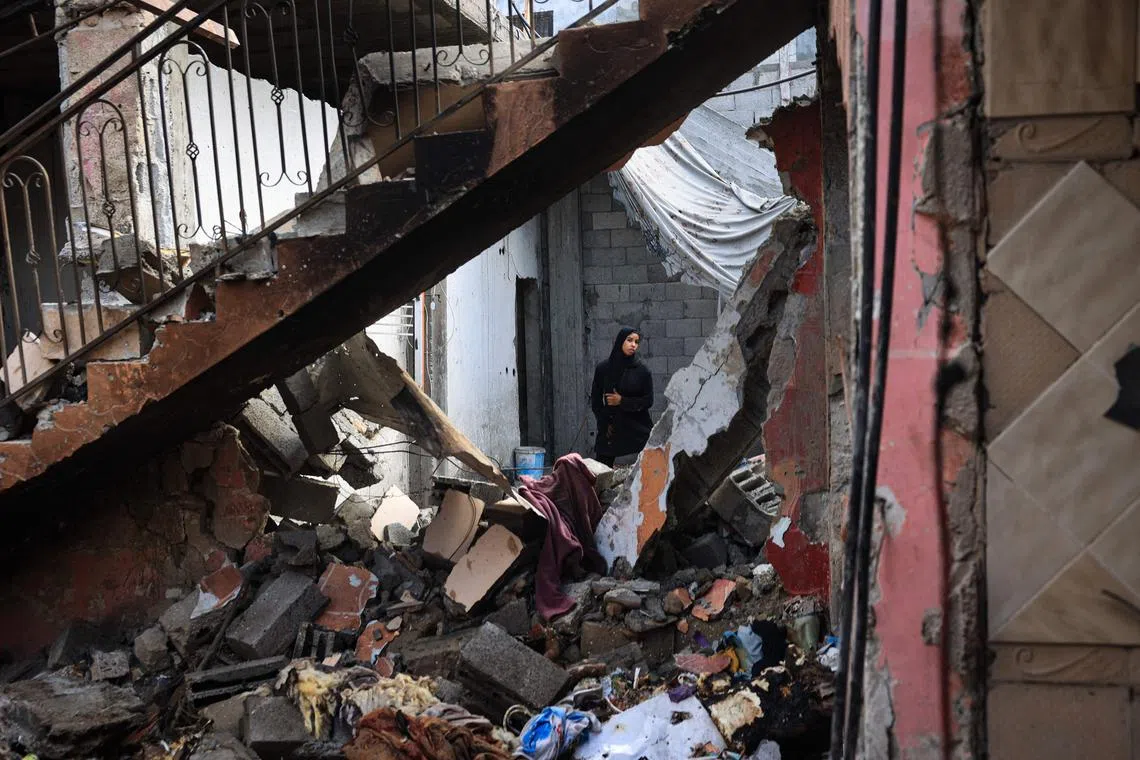 A Palestinian woman surveys the damage to a house following Israeli bombardment at the Al-Maghazi Palestinian refugee camp, in the central Gaza Strip on July 15, 2024.