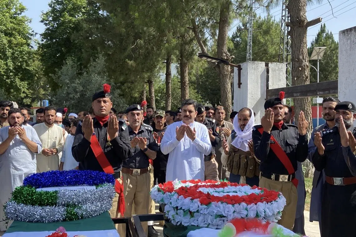 Police officials and relatives attend the funeral of police officers killed while escorting a polio vaccination team in Bajaur, Pakistan, on 18 May.