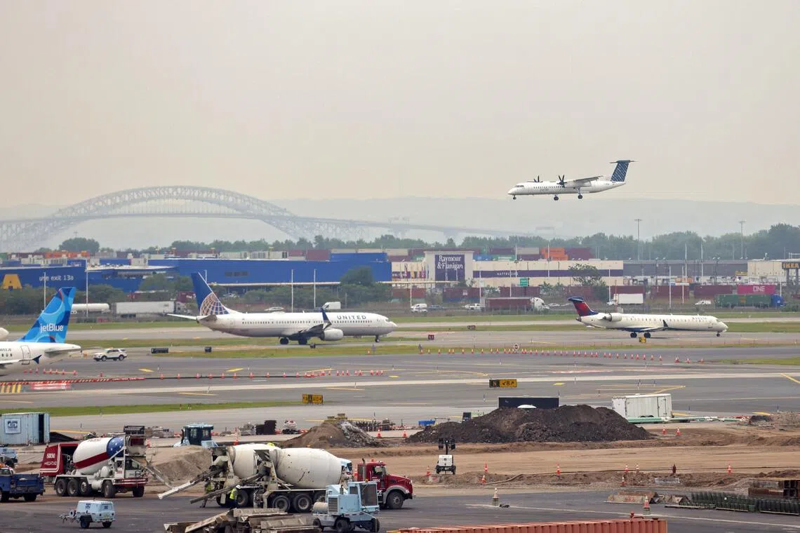 epa12103674 A plane lands at Newark Liberty International Airport, which has been experiencing a shortage of air traffic controllers, as other planes wait in a queue on the tarmac in Newark, New Jersey, USA, 15 May 2025. Newark has had three communications blackouts in more than a week, rendering the control tower unable to track or communicate with planes for up to 90 seconds.  EPA-EFE/SARAH YENESEL