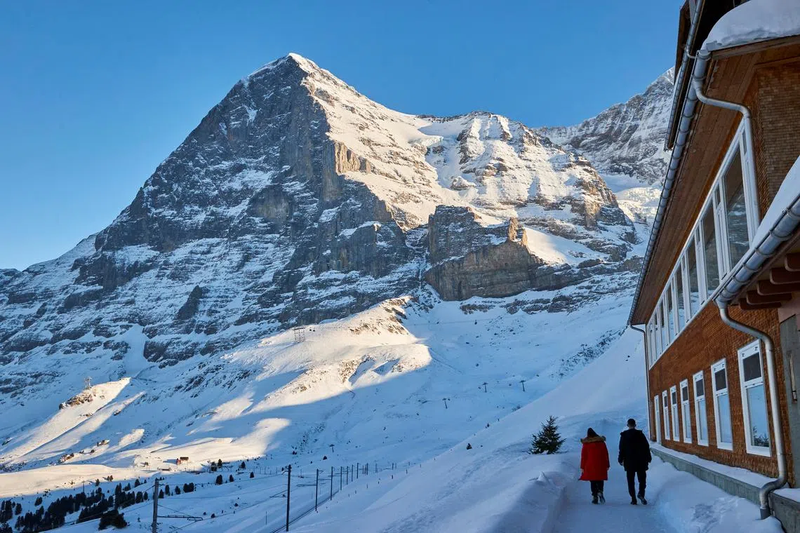 FILE PHOTO: People walk in front of the North face of the Eiger mountain at the Kleine Scheidegg in Wengen, Switzerland, January 14, 2022. REUTERS/Denis Balibouse/File Photo
