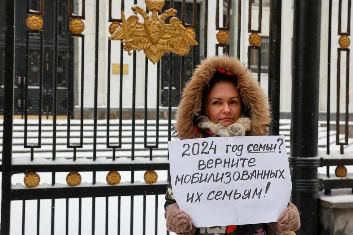 Ms Maria Andreeva holds a placard outside the Russian defence ministry in Moscow. It reads: "Is 2024 (declared) the Year of the Family? Get the mobilised (soldiers) back to their families!"