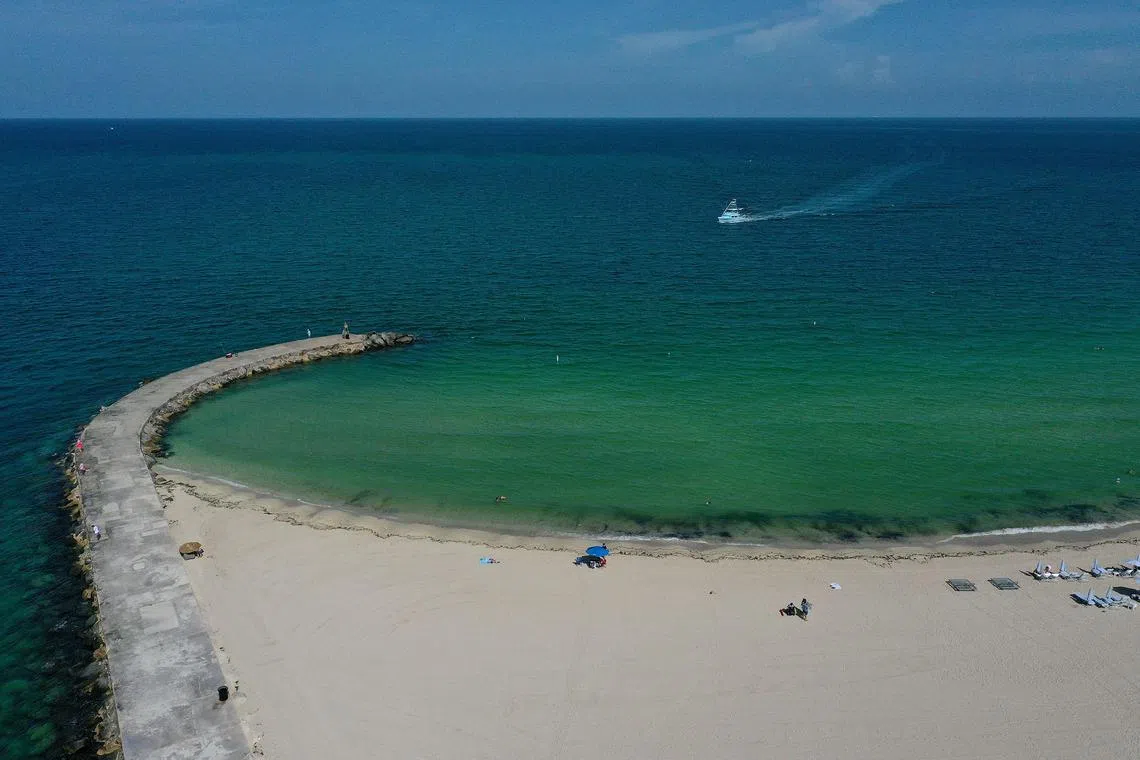 MIAMI, FLORIDA - JULY 11: In an aerial view, a boat arrives at the Haulover inlet from the Atlantic Ocean to on July 11, 2023 in Miami, Florida. The surface ocean temperatures in parts of Florida are 92 to 96 degrees Fahrenheit, the warmer coastal ocean water is threatening Florida's coral reefs, and could create stronger tropical storms and hurricanes.   Joe Raedle/Getty Images/AFP (Photo by JOE RAEDLE / GETTY IMAGES NORTH AMERICA / Getty Images via AFP)