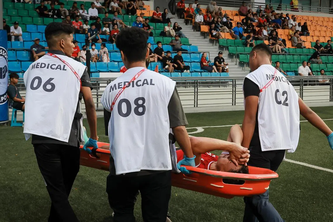 Singapore’s Ikhsan Fandi (red, 9) being carried off the field after getting injured while playing against Maldives in the international football friendly match at Jalan Besar Stadium, 17 Dec 2022.