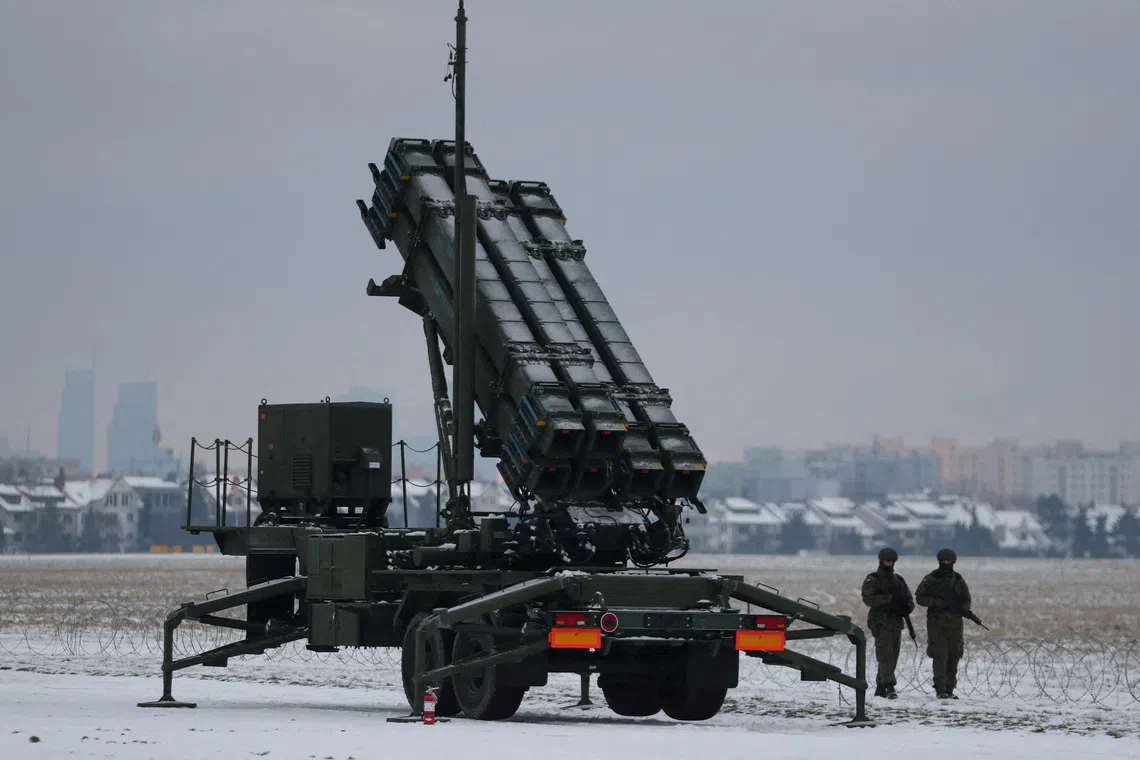 FILE PHOTO: Servicemen patrol in front of the Patriot air defence system during Polish military training on the missile systems at the airport in Warsaw, Poland February 7, 2023. REUTERS/Kacper Pempel/File Photo