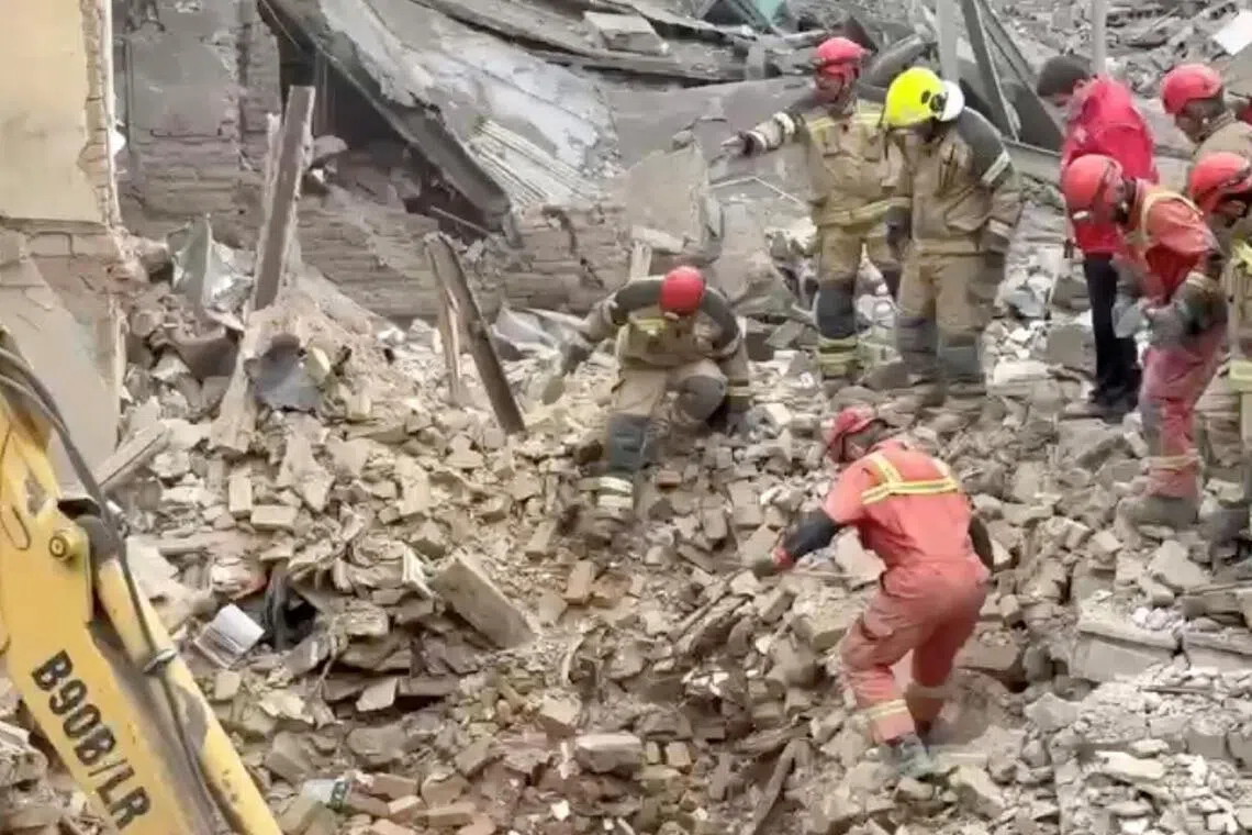 A still image from video shows Iranian Red Crescent aid workers and firefighters working on March 14 at a residential site damaged by air strikes in Tehran.
