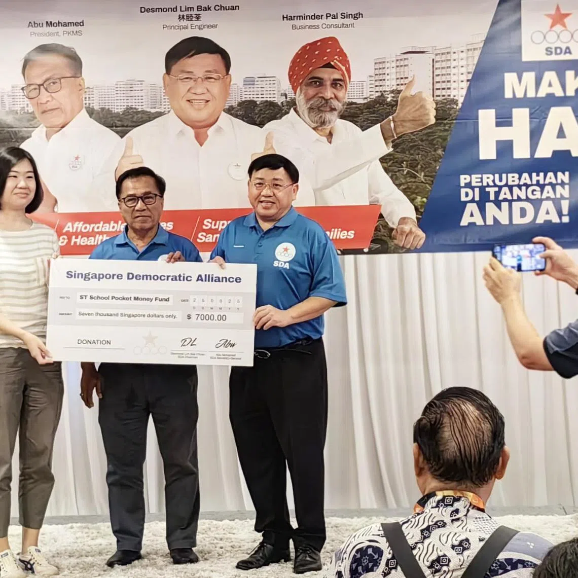 SDA chairman Desmond Lim (at right) and secretary-general Abu Mohamed handing over the initial amount raised to STSPMF general manager Lau Hui Ling on May 25.