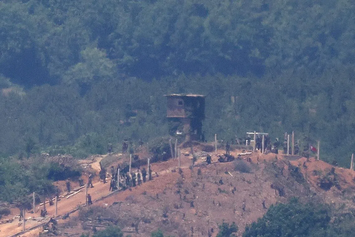 FILE PHOTO: North Korean people work on a military fence near their guard post at the inter-Korean border in this picture taken from the observation deck near the demilitarized zone that separates the two Koreas in Paju, South Korea, June 4, 2024.    REUTERS/Kim Hong-Ji