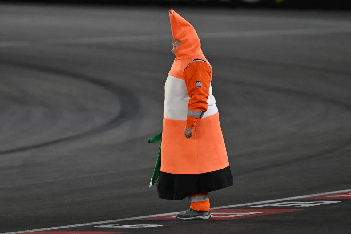 A track worker dresses as a traffic cone before the start of the Las Vegas Formula One Grand Prix in Las Vegas, Nevada on Nov 23, 2024. 
