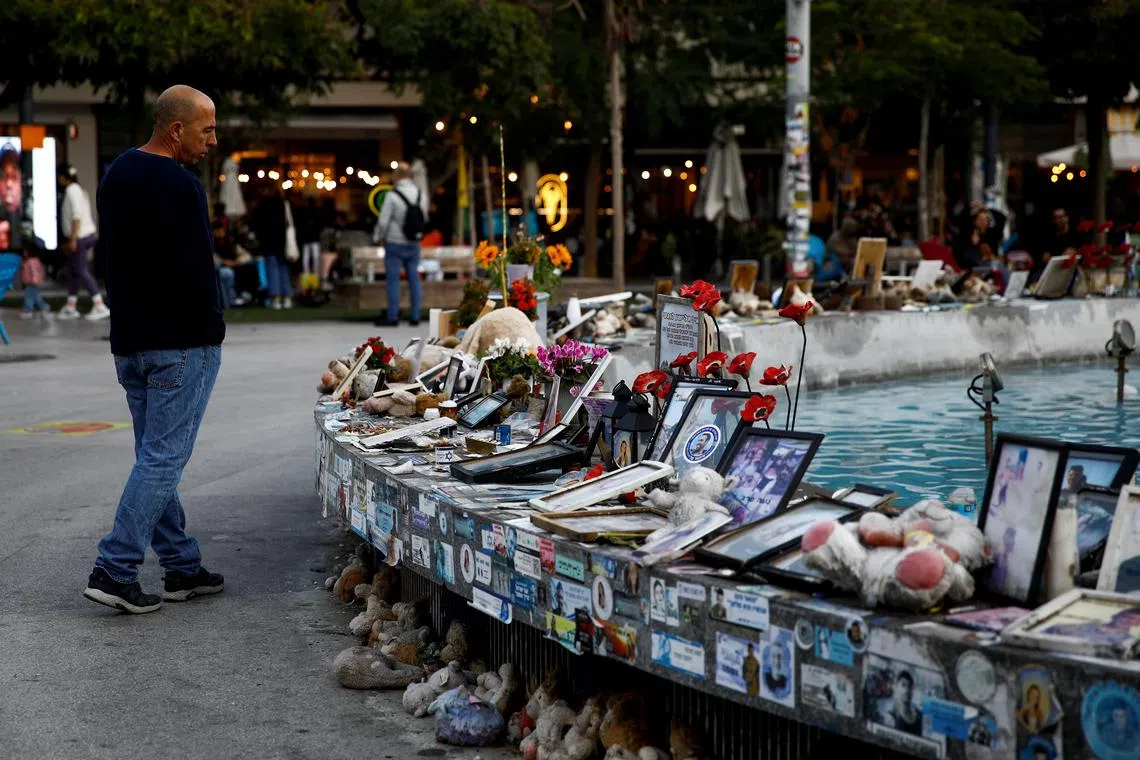 FILE PHOTO: A man looks at pictures and memorabilia related to fallen soldiers, hostages and people killed during the October 7, 2023 attack by Hamas, ahead of a ceasefire between Israel and Hamas, at a public square in Tel Aviv, Israel, January 16, 2025. REUTERS/Shir Torem/File Photo
