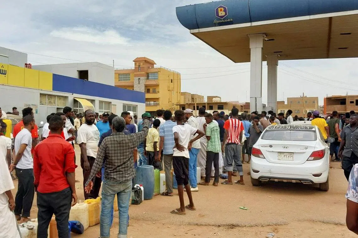 People gather to get fuel at a station as clashes continue in Khartoum, Sudan, on April 30.