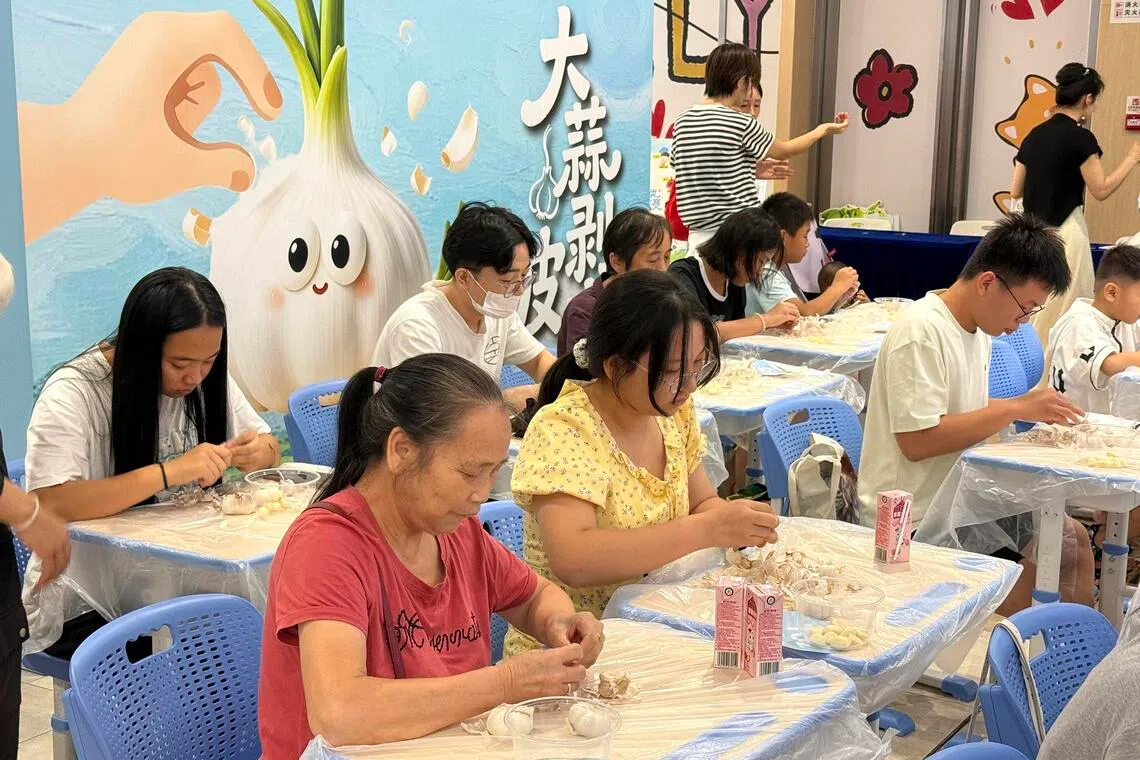 People participate in a garlic peeling contest at the Longgang Wanda Plaza in Shenzhen on Aug 8.