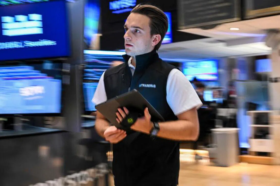 A trader works on the floor of the New York Stock Exchange (NYSE) at the opening bell on July 18, 2025, in New York City. Upbeat company earnings and healthy US data buoyed stock markets on Friday, pushing ongoing concerns about President Donald Trump's tariffs into the background. New York -- whose S&P 500 and Nasdaq Composite struck record highs on July 17 -- held on to gains, even if the Dow struggled a little at the start. Most European and Asian markets were pulled higher as well. (Photo by ANGELA WEISS / AFP)