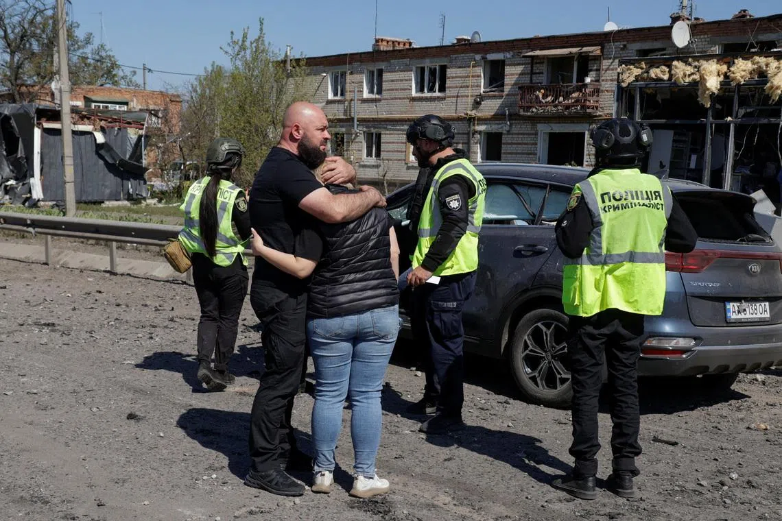Residents react next to a car with the body of their relative inside who was killed by a Russian missile strike in the town of Merefa, amid Russia's attack on Ukraine, in Kharkiv region, Ukraine May 4, 2026. REUTERS/Sofiia Gatilova