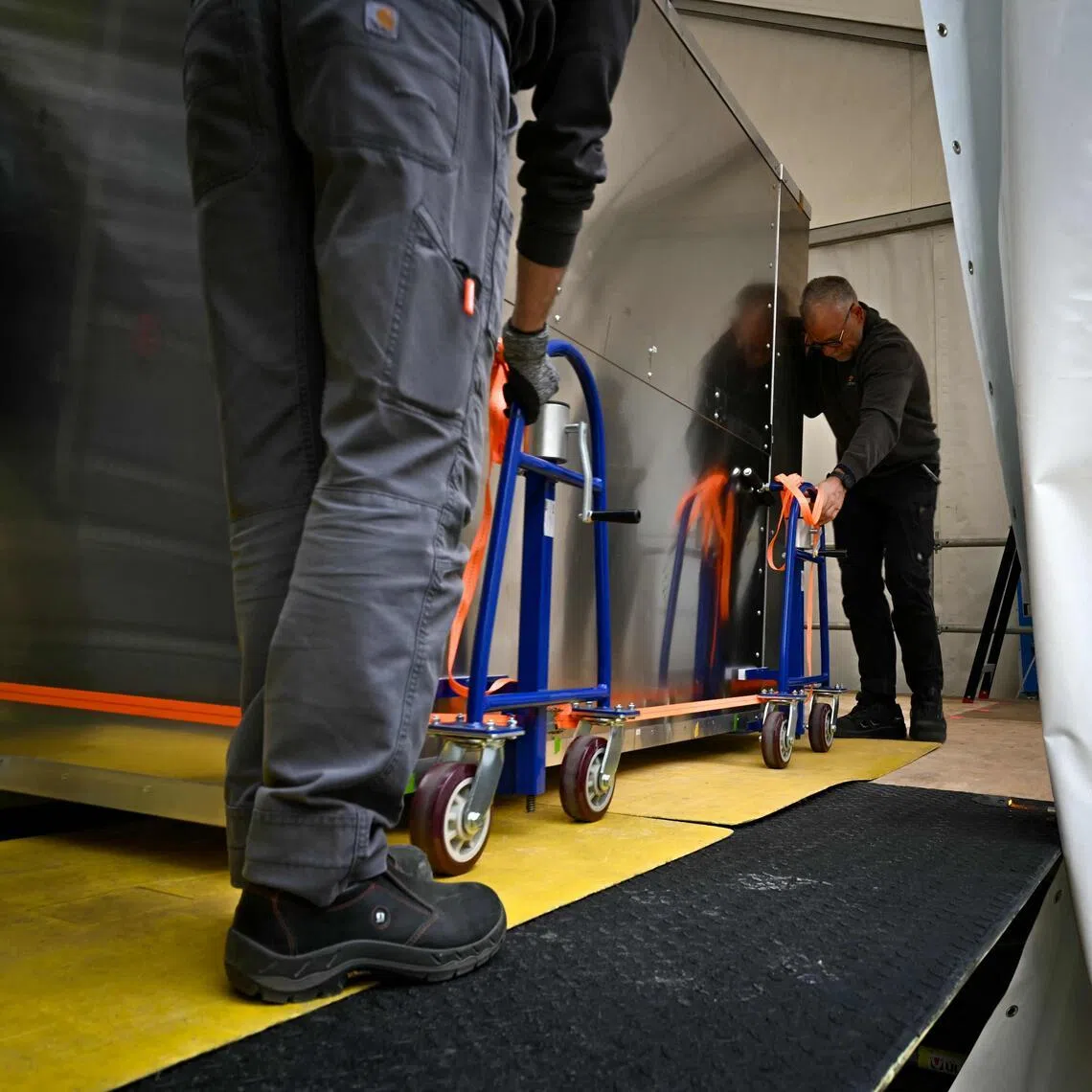 Workers move a fake Bayeux Tapestry box into a special conservation tent in Bayeux, northern France.

