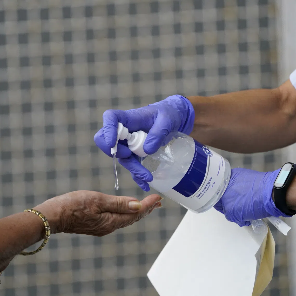 A medical team administers hand sanitiser to a resident of the Basque town of Azpeitia, Spain, August 17, 2020. REUTERS/Vincent West/File Photo
