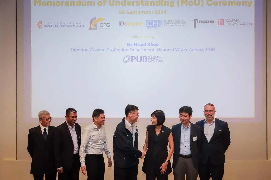 Professor Adrian Law, executive director, CFI Singapore, shaking hands with Ms Hazel Khoo, director, Coastal Protection Department, National Water Agency PUB, at the Memorandums of Understanding Signing Ceremony with five industry partners at Coastal Protection and Flood Resilience Institute Singapore's symposium  held at the NUS Engineering Auditorium on Sep 26, 2024.