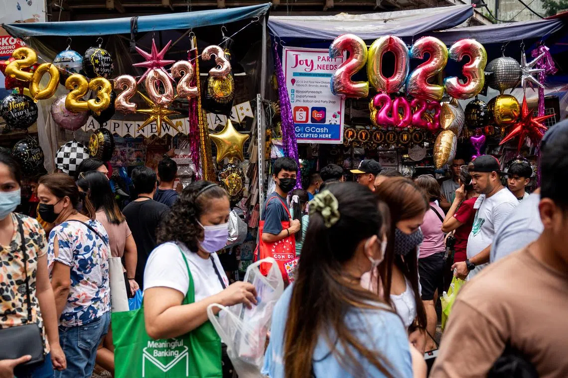 People shop at a public market ahead of New Year celebrations in Manila, on Dec 30, 2022.