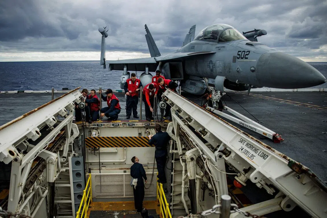 Sailors perform maintenance on one of the flight deck of the USS Gerald Ford on Oct 6, 2022.