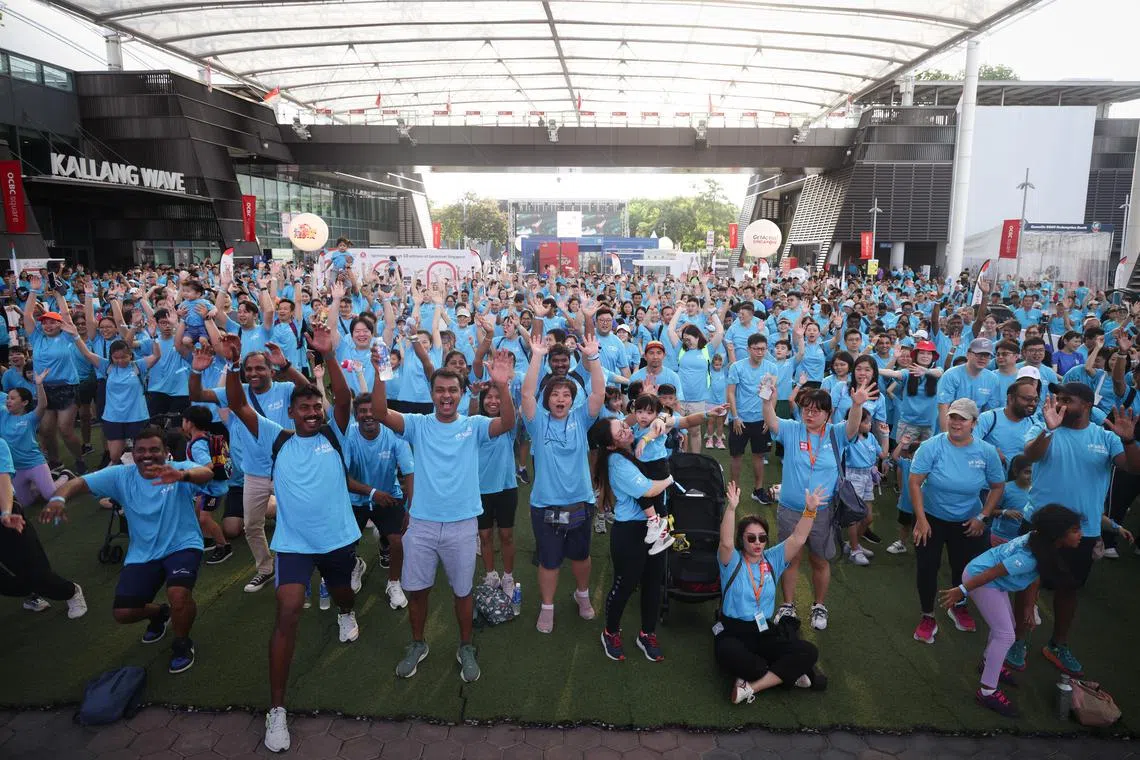 Participants do the kallang wave at Walk For Our Children 2025 at the Singapore Sports Hub Aug 17, 2025. 