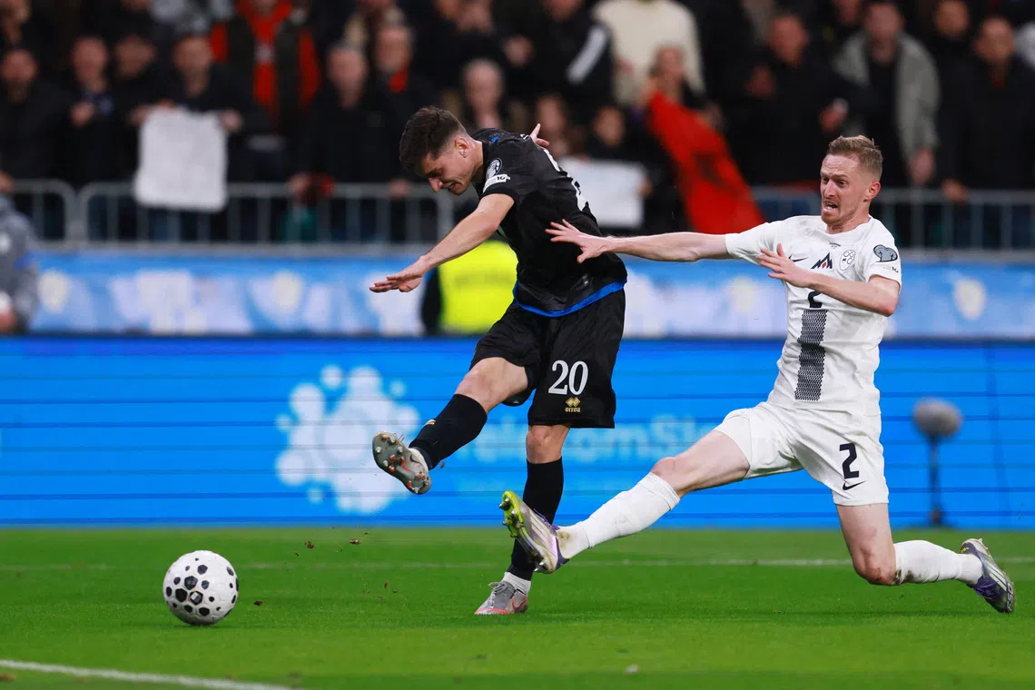 Soccer Football - FIFA World Cup - UEFA Qualifiers - Group B - Slovenia v Kosovo - Stadion Stozice, Ljubljana, Slovenia - November 15, 2025 Slovenia's Zan Karnicnik in action as Kosovo's Veldin Hodza shoots at goal REUTERS/Borut Zivulovic
